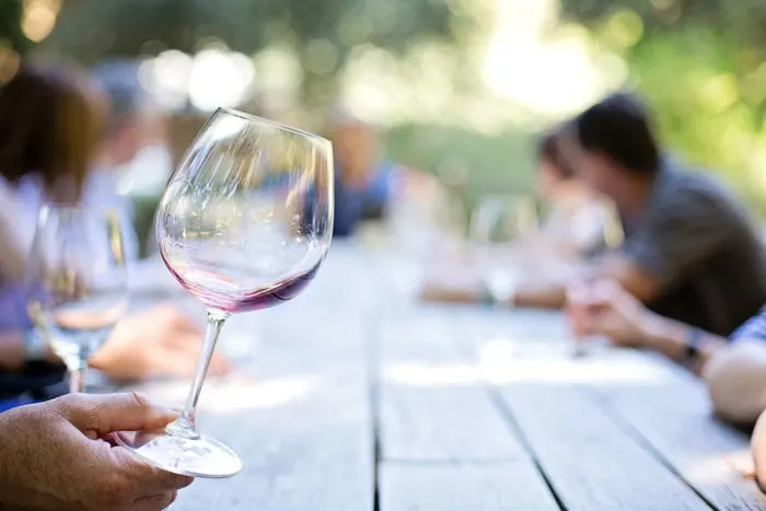 Wineglass and people talking around table