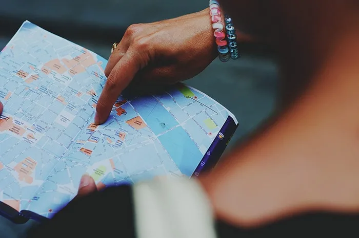 Woman pointing location on a map while preparing a trip to Brazil