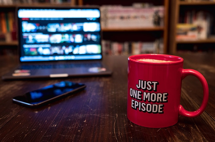 Red mug in front of television playing Brazilian shows on Netflix