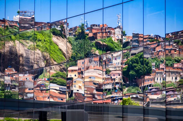 Reflection of a favela on the windows of a fancy building