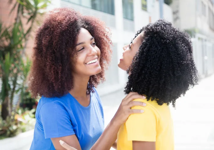 Brazilian friends greeting each other with a cheek kiss