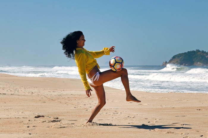 Brazilian woman playing soccer at the beach