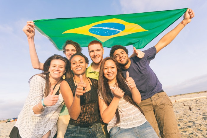 Multicultural group of Brazilians holding the flag